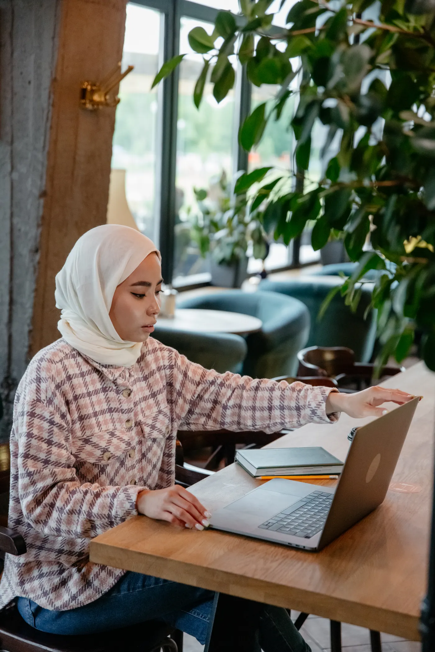 Ilustrasi perempuan berhijab belajar mandiri menggunakan laptop